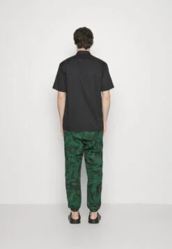 LACOSTE X NETFLIX UNISEX - Jogginghose - Green/black -Lacoste bf97fb3ea47f4a7aaf1248b5e0692b60